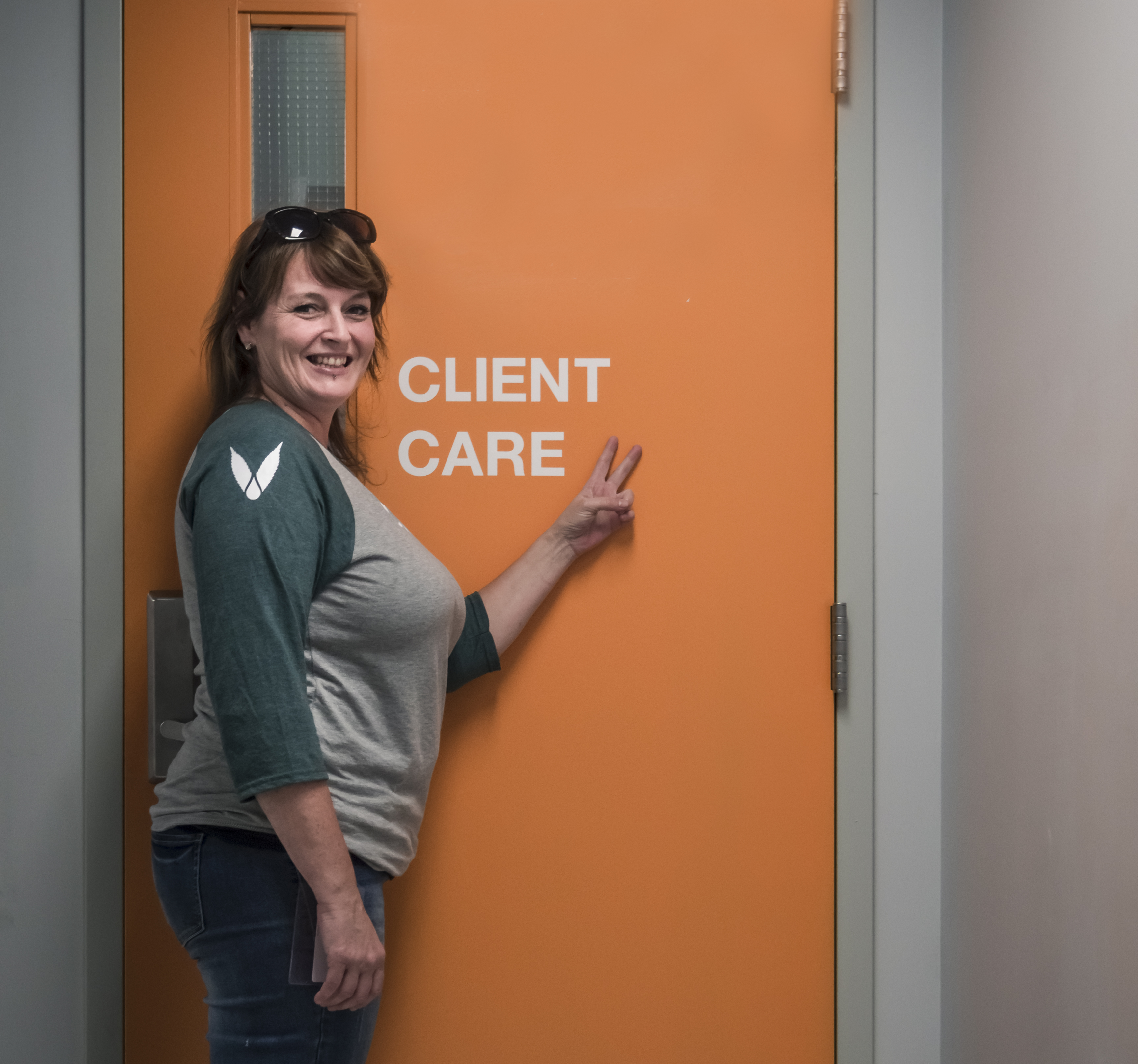 An image of the client care manager for an LP called INDIVA standing in front of a door labelled Client Care. 